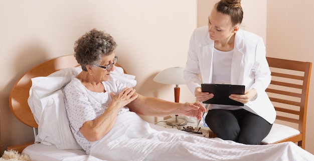 Foto bezoek van senior maatschappelijk werker aan een oude vrouw