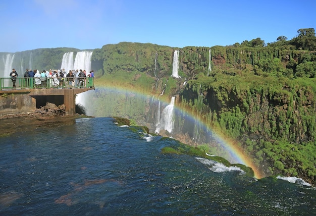 Bezoekers op het uitkijkbalkon van de Iguazu-watervallen aan de Braziliaanse kant onder de indruk van de regenboog Brazilië