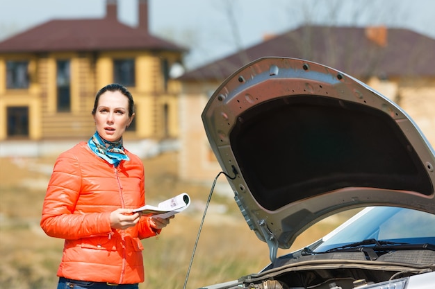 Bezorgd over het meisje in de kapotte auto met open motorkap Gebruikershandleiding