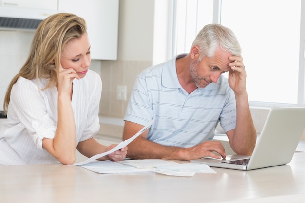 Bezorgd paar dat hun financiën met laptop uitwerkt