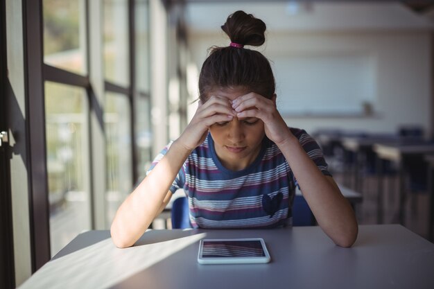 Bezorgd schoolmeisje zitten in de klas