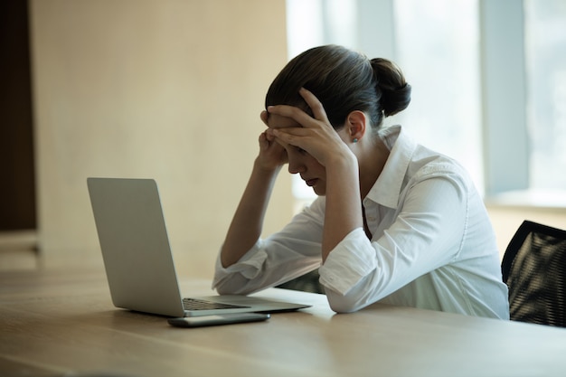 Foto bezorgd vrouwelijke directeur met behulp van laptop in vergaderruimte