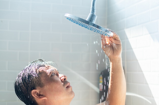 Bezorgde Aziatische man neemt een douche