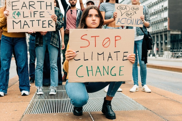 Bezorgde jonge vrouw die op vrijdag een stopbord met klimaatverandering omhooghoudt voor toekomstige straatdemonstraties