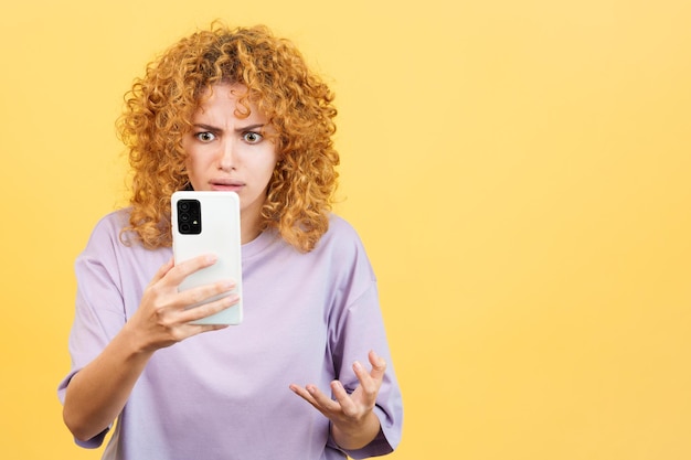 Bezorgde vrouw met krullend haar die mobiel gebruikt