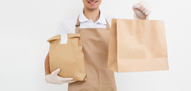 bezorger aan het werk in shirt met schort en beschermende handschoenen hand met pakket geïsoleerd witte achtergrond