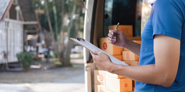 Bezorger die checklist op klembord ondertekent Mannelijke koerier die op klembord schrijft en streepjescode scant Oudere man die checklist van bezorging in busje bijwerkt