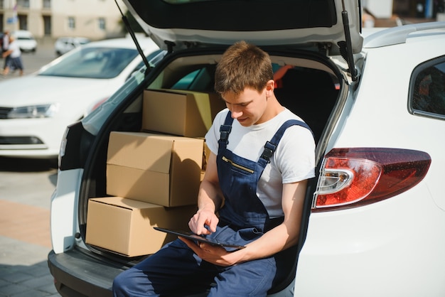 Bezorger die doos uit de auto haalt.