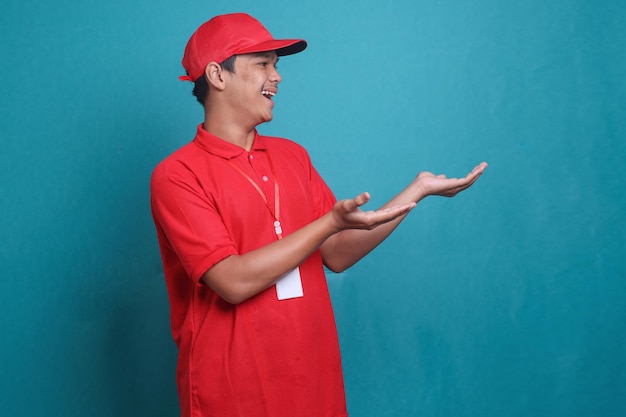 Bezorger in rode pet T-shirt uniforme werkkleding werkt als dealerkoerier die een gebaar maakt naar de