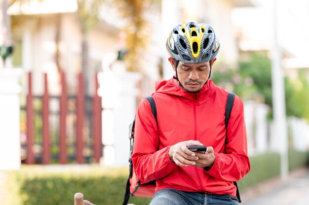 Bezorger in rood uniform Fietsen om producten thuis bij klanten af te leveren.