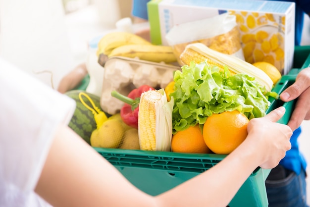 Bezorger levert boodschappen aan een vrouw