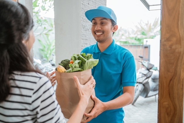 Bezorger levert wat boodschappen aan de vrouw