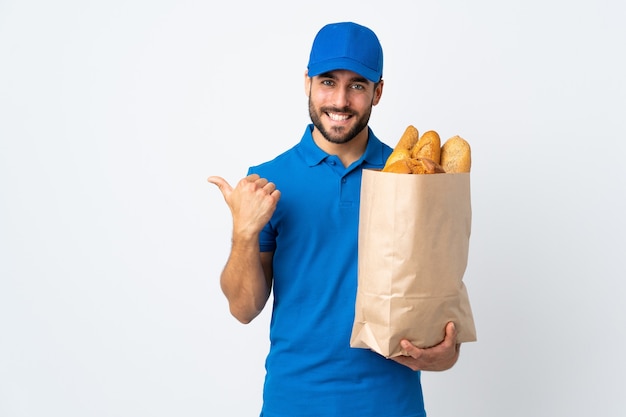 Bezorger met een zak vol brood die naar de zijkant wijst om een product te presenteren