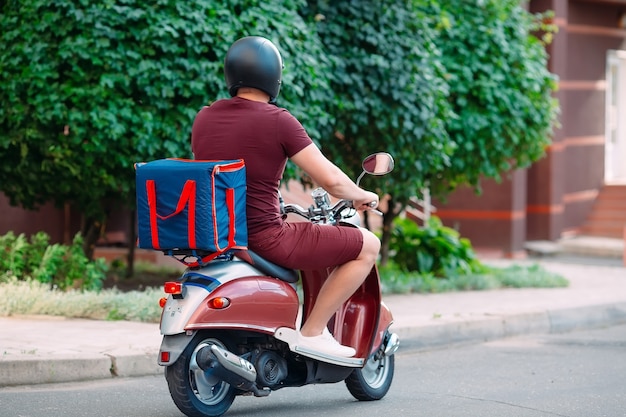 Bezorger met scooter voor huis