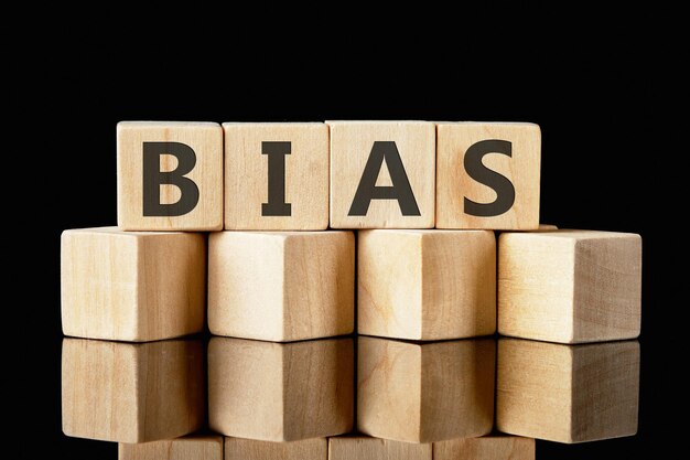 Bias text assembled from wooden cubes on a black background