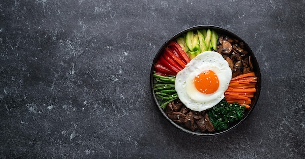 검은 배경에 비빔밥 전통적인 한국 요리 상위 뷰 복사 공간