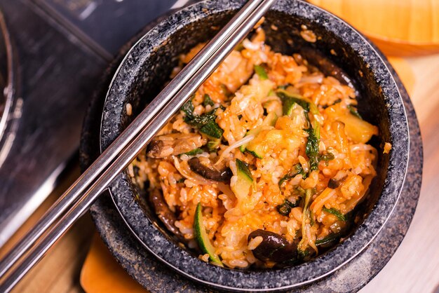 Photo bibimbap in a black heated stone bowl korean traditional dish bibimbap mixed rice with vegetables