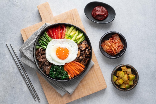 Foto bibimbap su uno sfondo di cemento tradizionale piatto coreano vista dall'alto