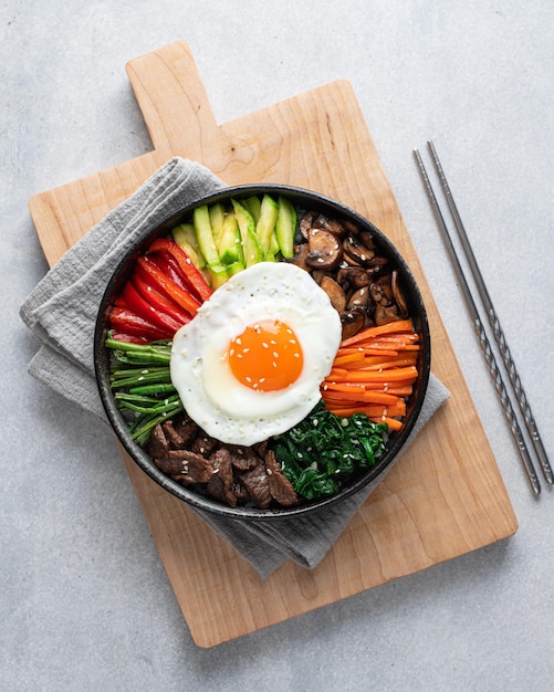 Photo bibimbap on a concrete background traditional korean dish top view