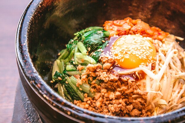 Foto bibimbap in una ciotola di pietra riscaldata cibo coreano