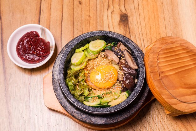 Bibimbap in een zwarte verwarmde stenen kom Koreaanse traditionele schotel bibimbap gemengde rijst