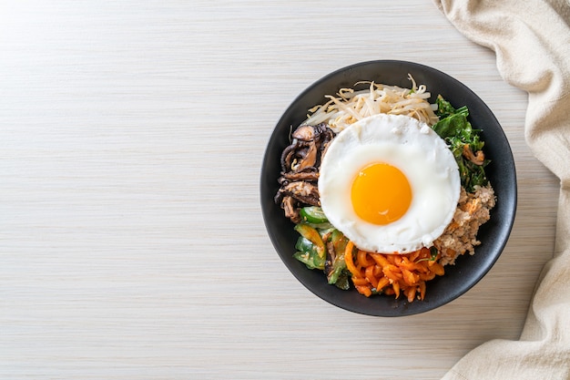 ビビンバ、ご飯と目玉焼きの韓国のスパイシーサラダ-伝統的な韓国料理のスタイル