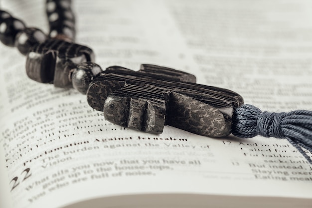 Bible and a crucifix on an old wooden table