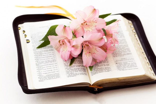 Bible and flowers on white background