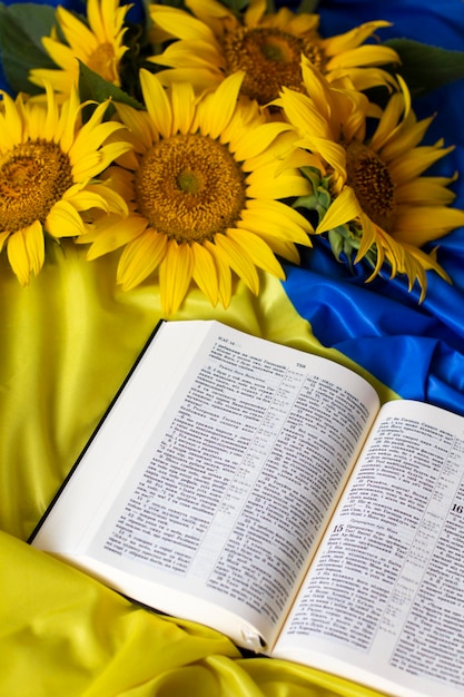 Foto bibbia sacra scrittura e girasoli sullo sfondo della bandiera dell'ucraina