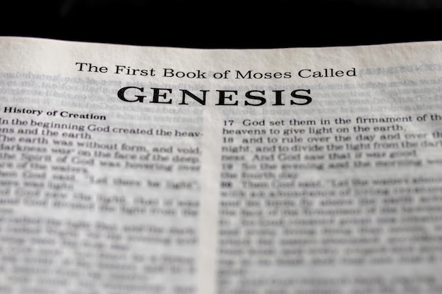 Photo the bible is open to a page that says the first book of moses called genesis.