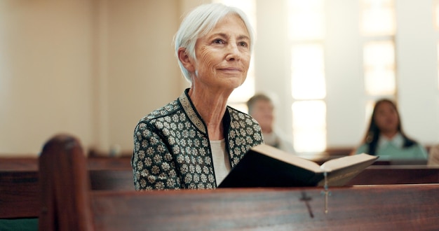 Bible religion and a senior woman in a church for a sermon on faith or christian belief while sitting in a pew Prayer worship or reading with an elderly female person hearing about God and Jesus