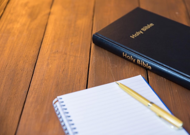 Bible with notepad on table