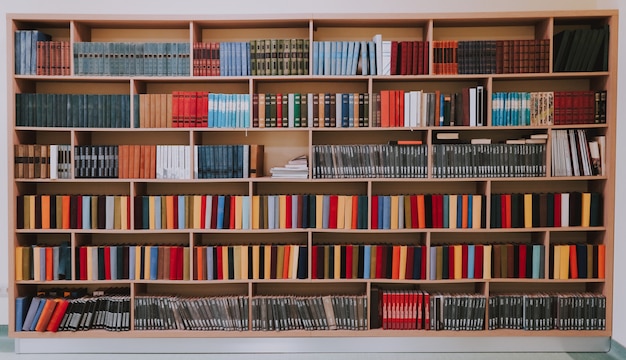 Bibliotheek of winkel met boekenkasten. Boekenplanken in de bibliotheek of grote boekenkast met heel veel boeken.