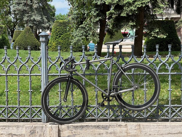 Bicycle attached to a metal fence in the park