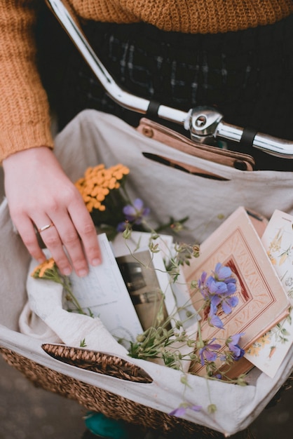 Bicycle basket with decor. Flowers and postcards in a basket. Lifestyle