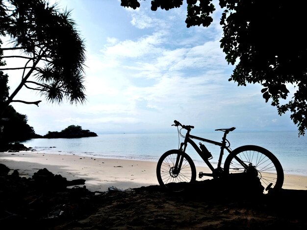 Bicycle on beach against sky