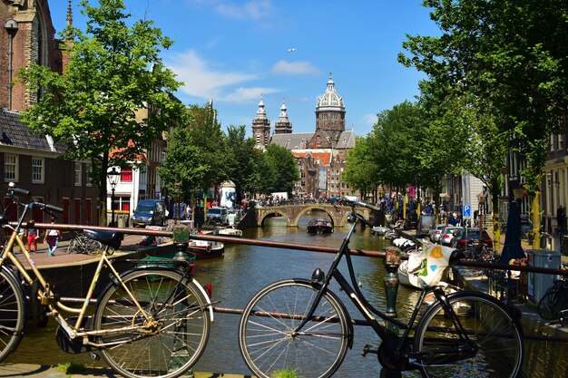 Bicycle by canal against buildings in city