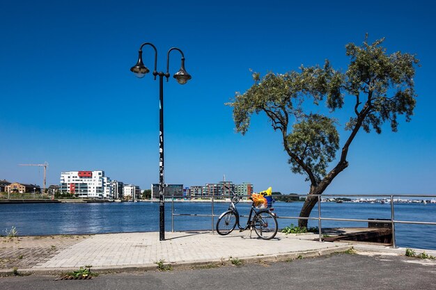 Bicycle by sea against clear blue sky