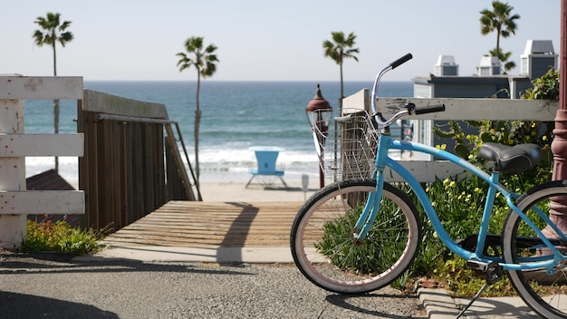 Велосипед крейсер байк на берегу океана, побережье Калифорнии, США. Летний цикл, лестницы и пальмы.