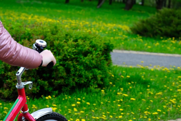 Велосипедный руль в руках ребека на размытом фоне травы с местом для текста