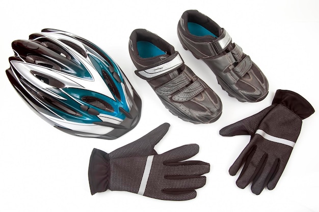 Bicycle helmet, gloves and cycling shoes on a white background