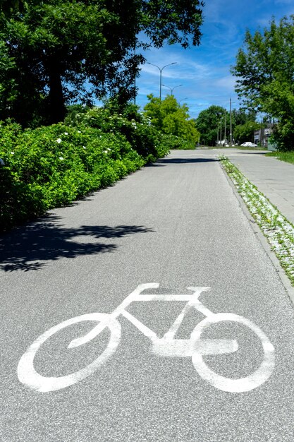 Photo bicycle lane sign applied with white paint on asphalt vertical