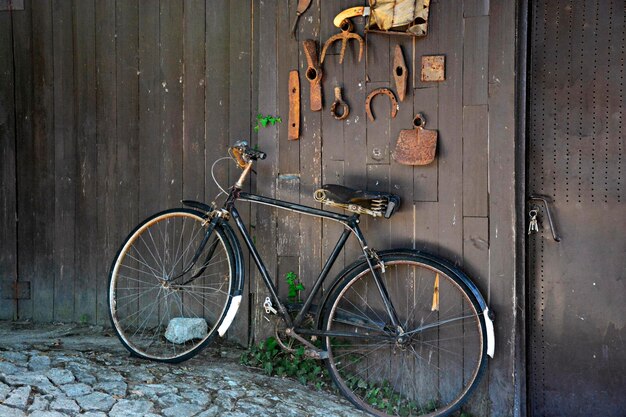 写真 木製の壁に寄りかかっている自転車