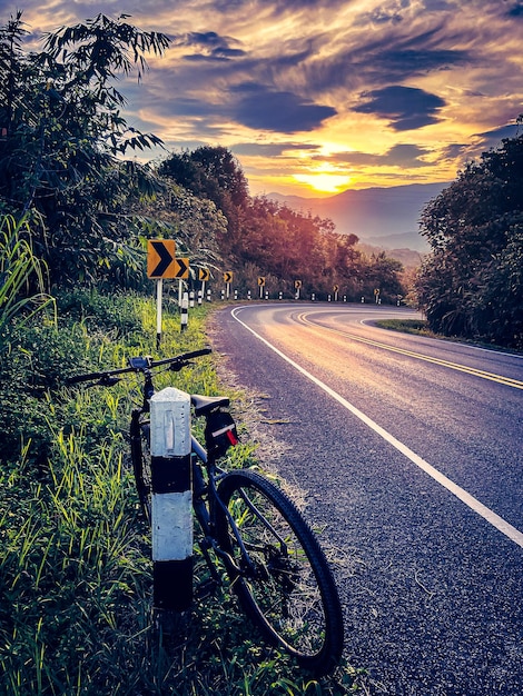 美しい自然の中の山道の自転車。サンセットライト