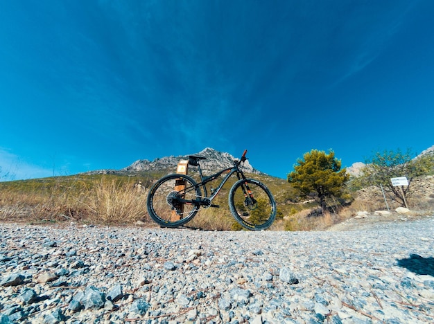 写真 明るい空を背景に岩の上で自転車に乗る