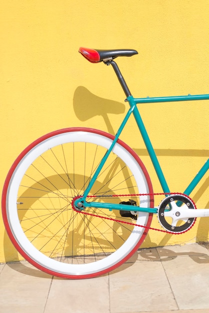 bicycle parked against yellow wall