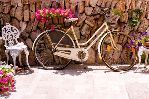 Photo bicycle parked by stone wall