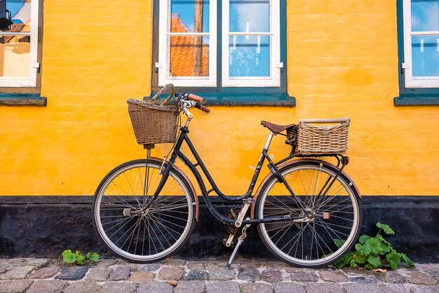 Bicycle parked near yellow wall of an old house in a classical traditional European village.