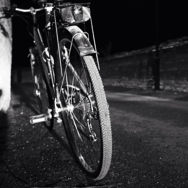 Bicycle parked on sidewalk at night