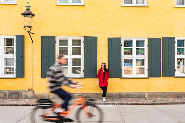 Bicycle passing in front of a tourist next to a traditional Danish house